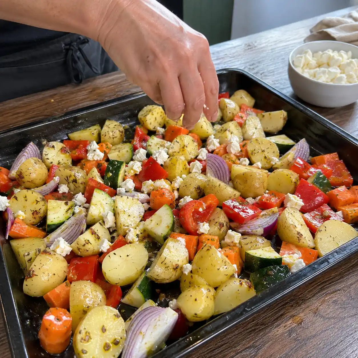 Zubereitung von Ofengemüse Kartoffeln Feta auf dem Backblech vor dem Rösten