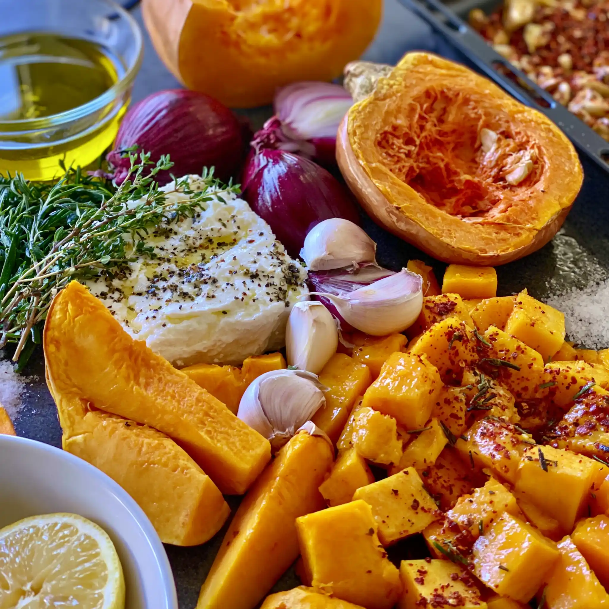 Zutaten für Ofenkürbis mit Feta mit Hokkaido, Feta, roter Zwiebel, Knoblauch, Olivenöl und Kräutern